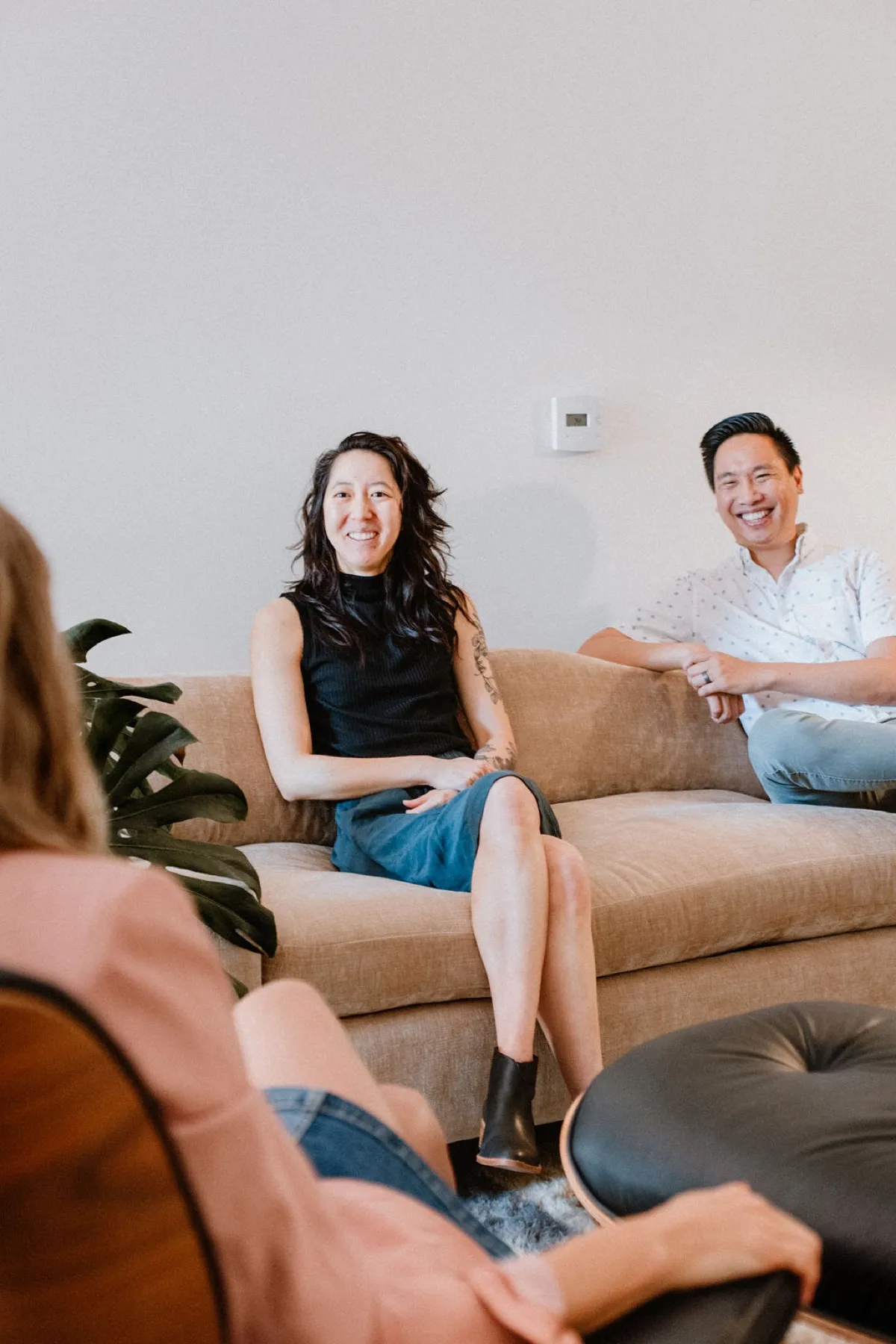 A couple on a couch with their therapist during a couples therapy session in North County San Diego