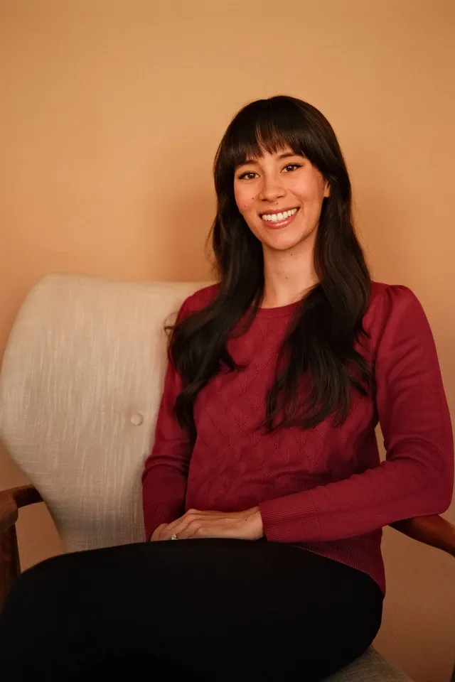 Lillian Mecum, PhD, postdoctoral fellow at Coastal Therapy Group, seated in an armchair