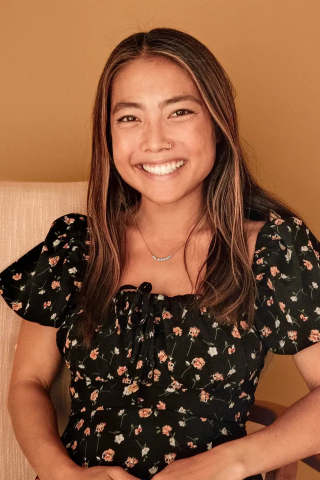 Dr. Naomi Wu, PsyD, licensed psychologist for young adults and teens, seated in an armchair at Coastal Therapy Group in Carlsbad, CA