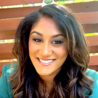 Anjali Ferguson, PhD, smiling, with long dark hair, wearing a green blazer
