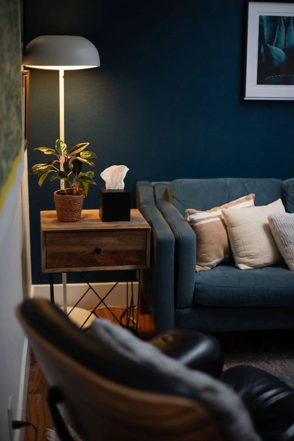 A side table with a small stack of books beside a therapy chair.